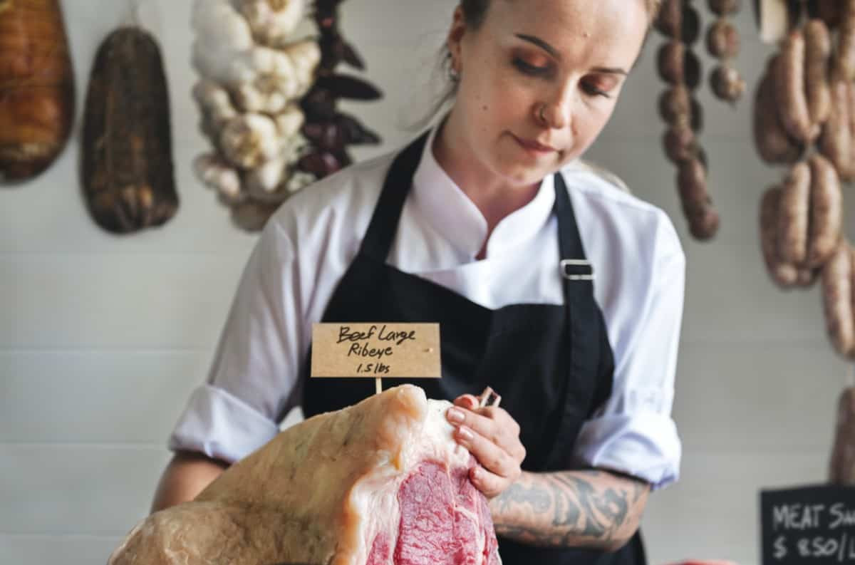 female butcher with beef ribeye