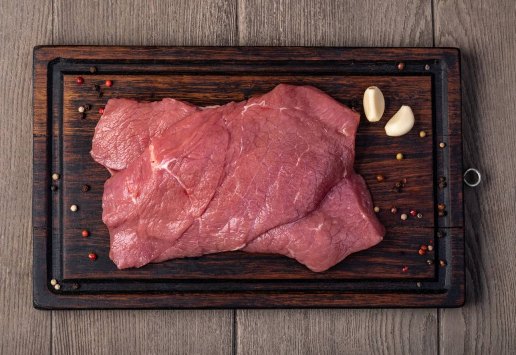 raw meat on wooden cutting board